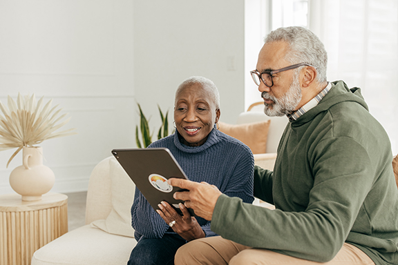 Older couple holding an ipad during a virtual patient consultation