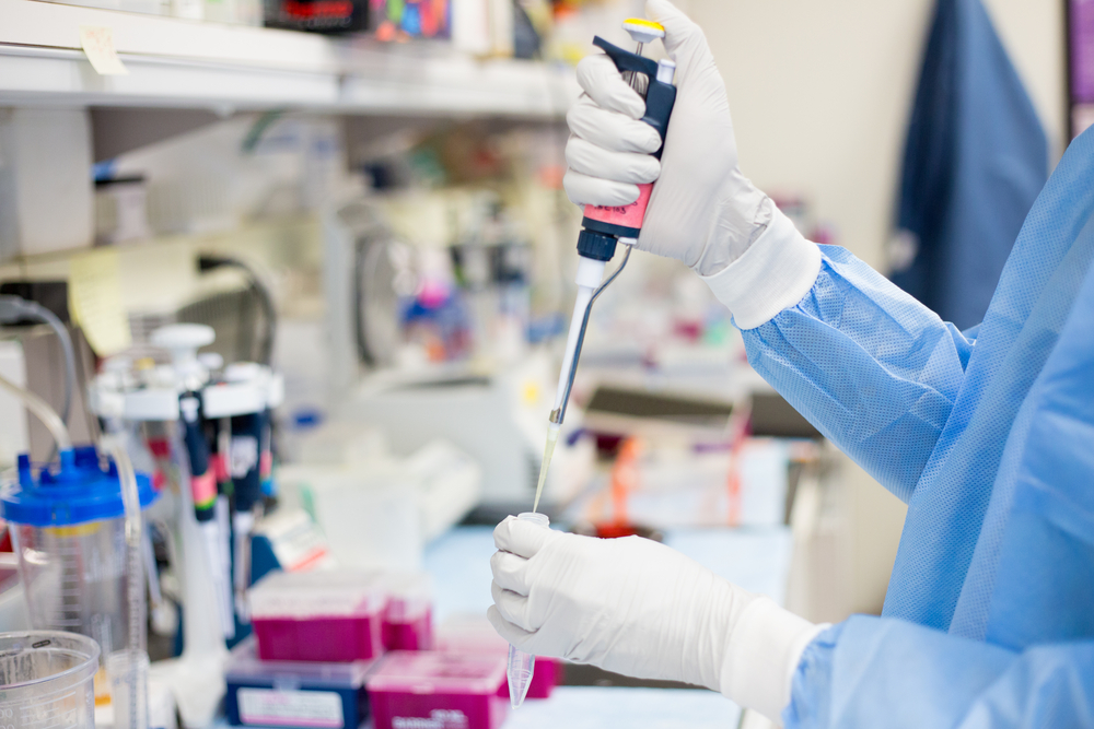 lab technician pipetting sample in laboratory